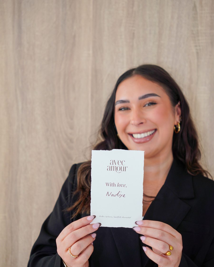 Nadiye smiling, holding her With love card