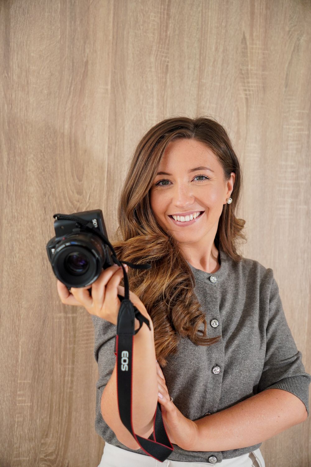 Georgia holding a camera and smiling